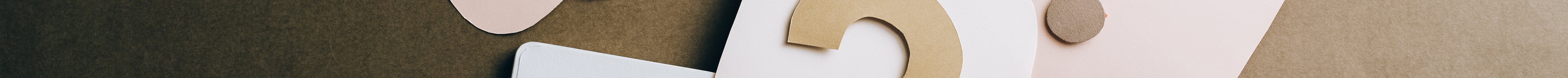Flat lay of question mark paper crafts on a notebook, symbolizing questions and ideas.