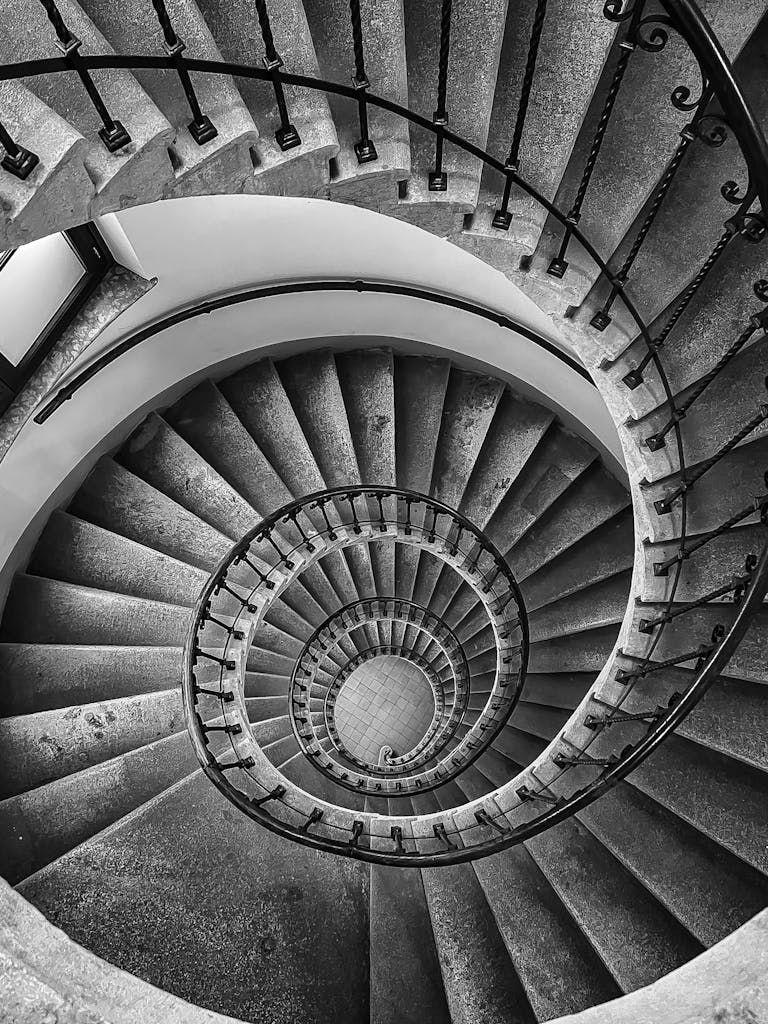 Black and white photo of an intricate spiral staircase with a diminishing perspective in Vienna.
