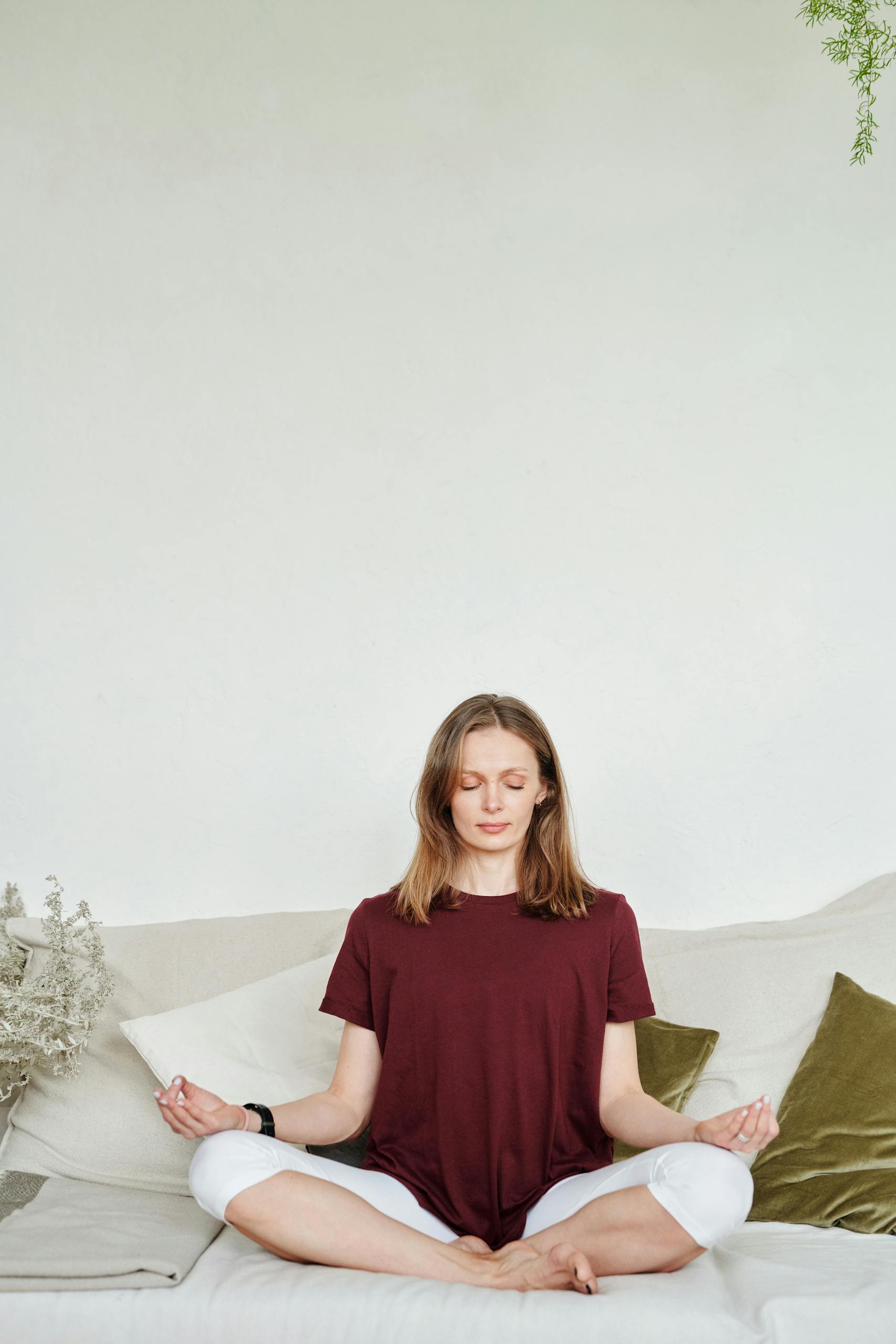 Peaceful woman meditating in a serene indoor setting, focusing on relaxation and mindfulness.